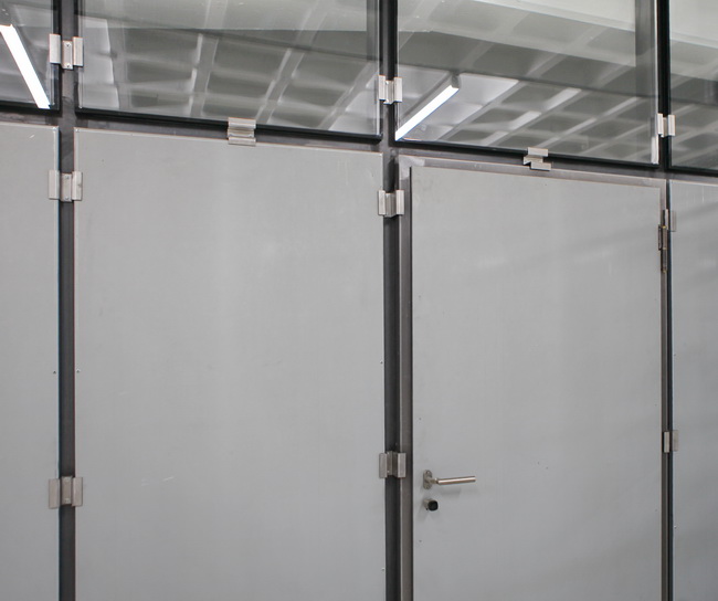 Atelier Trennwände mit Türen Verglasung und Rolltor aus rohem Stahl